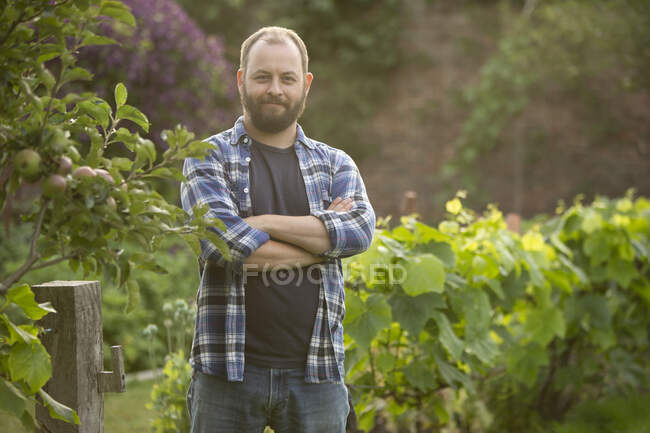 Portrait confident handsome man with beard in garden — Stock Photo