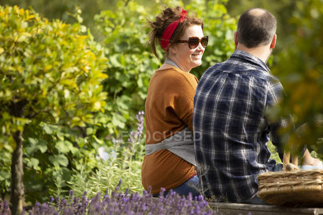 Coppia che si prende una pausa dal giardinaggio nel soleggiato cortile estivo — Foto stock