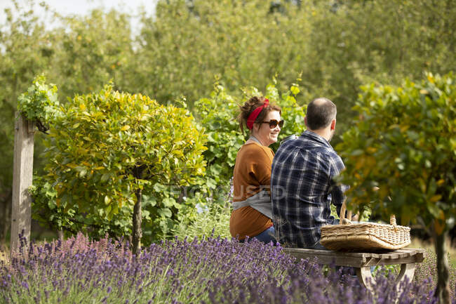 Пара отдыхает от садоводства в солнечном летнем саду — стоковое фото