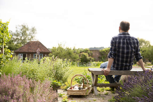 Mann macht Gartenpause im idyllischen, sonnigen Hüttengarten — Stockfoto