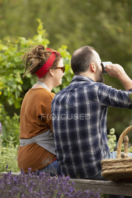 Пара отдыхает от садоводства в летнем саду — стоковое фото