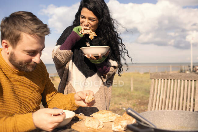 Coppia felice mangiare sul patio soleggiato sulla spiaggia — Foto stock