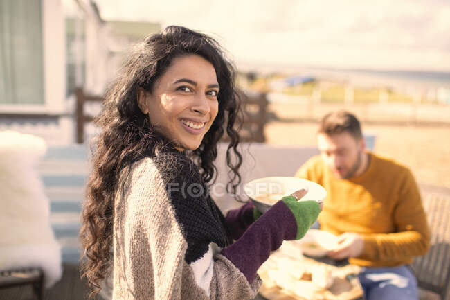 Portrait happy woman eating on sunny patio — Stock Photo