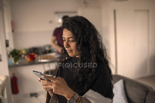 Женщина с помощью смартфона дома — стоковое фото
