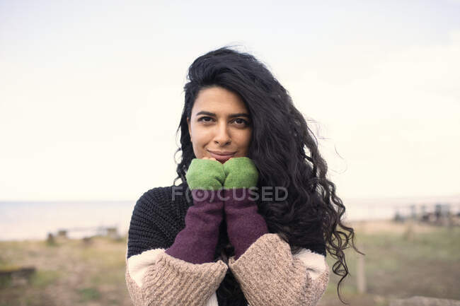 Portrait belle femme avec de longs cheveux noirs bouclés sur la plage — Photo de stock