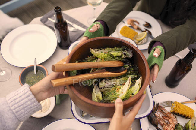 Freunde reichen Salat über Terrassentisch — Stockfoto