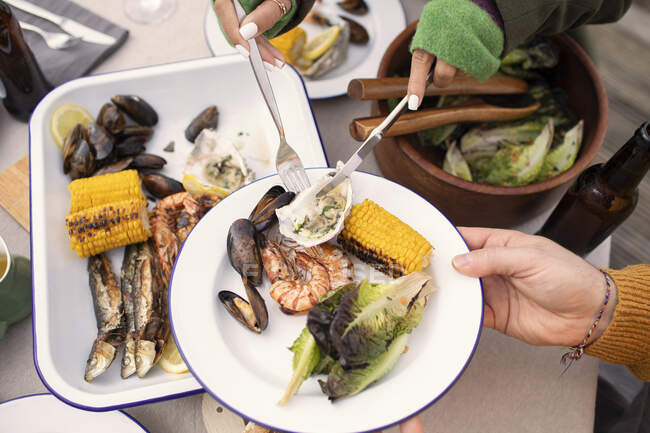Вид зверху пари, що подає свіжі морепродукти за столом патіо — стокове фото