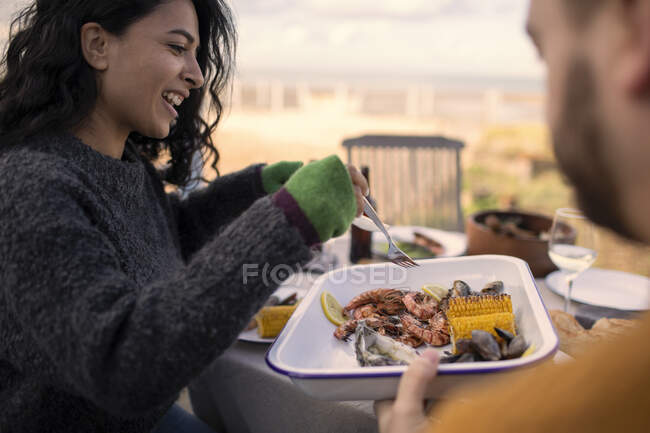 Casal desfrutando de almoço de frutos do mar no pátio — Fotografia de Stock