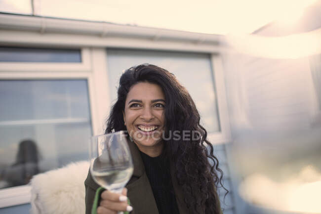 Щаслива безтурботна жінка насолоджується білим вином на патіо — стокове фото