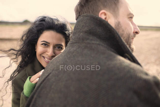 Retrato feliz pareja cariñosa en abrigos de invierno - foto de stock
