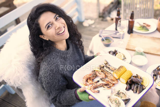 Portrait femme heureuse avec des fruits de mer frais à la table de patio — Photo de stock