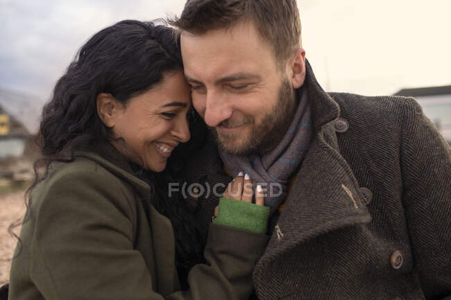 Feliz casal afetuoso em casacos de inverno abraçando — Fotografia de Stock
