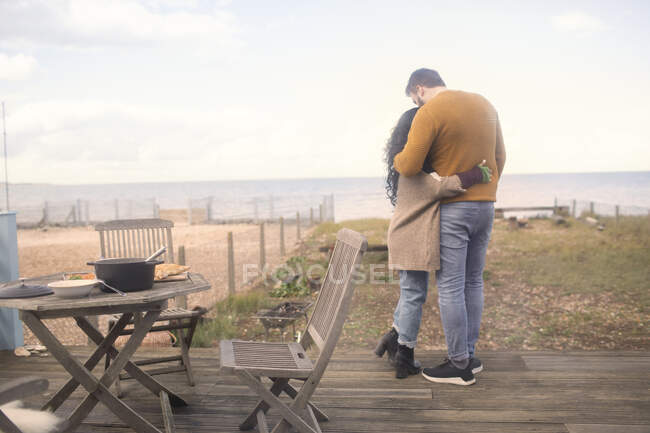 Affectionate couple hugging on ocean beach patio — Stock Photo