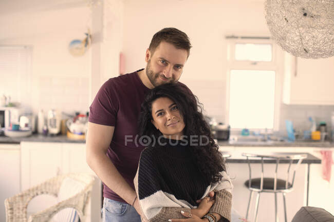 Retrato feliz casal atraente abraçando na cozinha — Fotografia de Stock