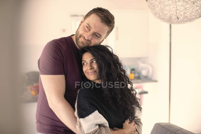 Feliz casal afetuoso abraçando em casa — Fotografia de Stock