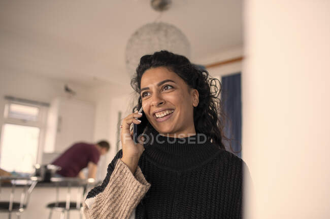 Щаслива жінка розмовляє по смартфону вдома — стокове фото