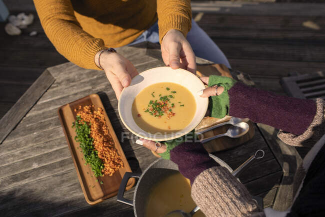 Pareja con sopa fresca en patio soleado - foto de stock