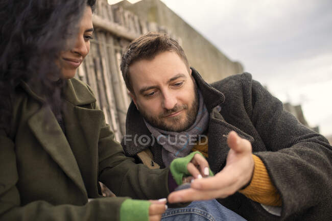 Couple in winter coats at beach — Stock Photo