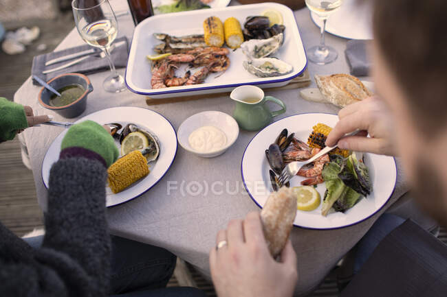 Casal desfrutando de frutos do mar frescos na mesa do pátio — Fotografia de Stock