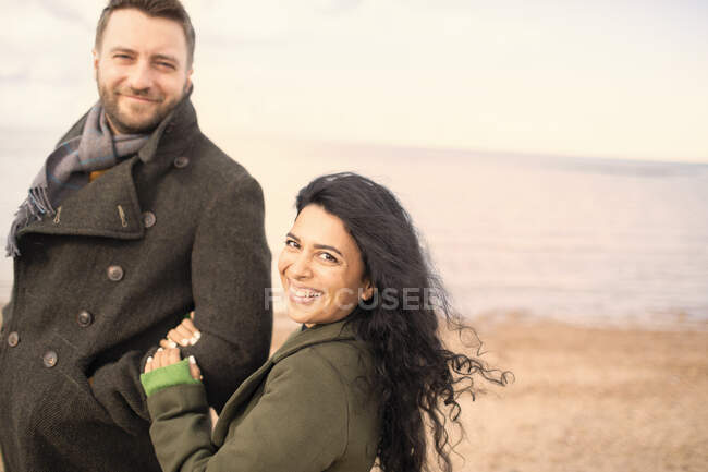 Portrait happy carefree couple on winter ocean beach — Stock Photo