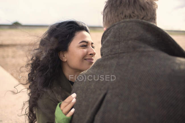 Felice donna abbracciare fidanzato sulla spiaggia — Foto stock