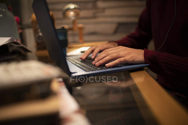 Close up young man working at laptop on desk in home office — Stock Photo
