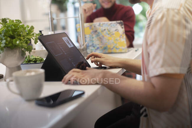 Jovem usando tablet digital no balcão da cozinha — Fotografia de Stock