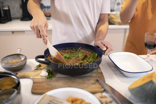 Young man cooking dinner in kitchen — Stock Photo