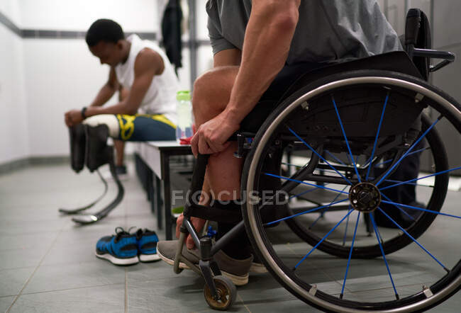 Парализованный спортсмен в инвалидной коляске в раздевалке — стоковое фото