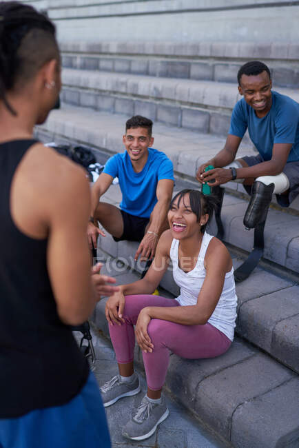 Happy athletes talking on steps — Stock Photo