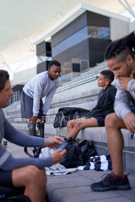 Jovens atletas conversando em arquibancadas de estádio — Fotografia de Stock