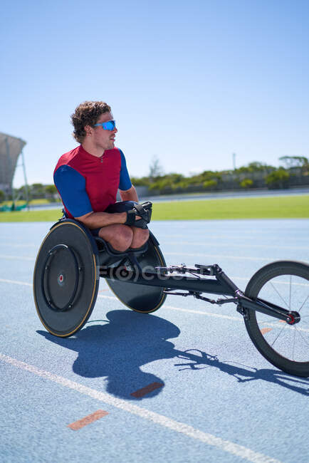 Atleta de cadeira de rodas em pista de esportes ensolarados — Fotografia de Stock