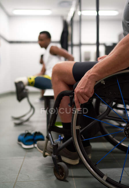 Wheelchair and amputee athletes in locker room — Stock Photo