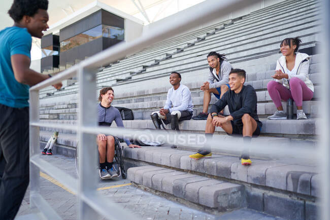 Athlete friends talking in stadium bleachers — Stock Photo