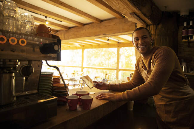 Portrait happy male coffee shop owner working behind counter — Stock Photo
