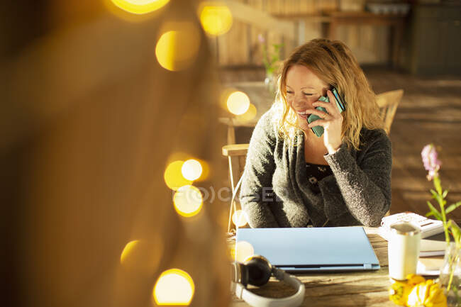 Glückliche Geschäftsfrau telefoniert in sonnigem Café — Stockfoto