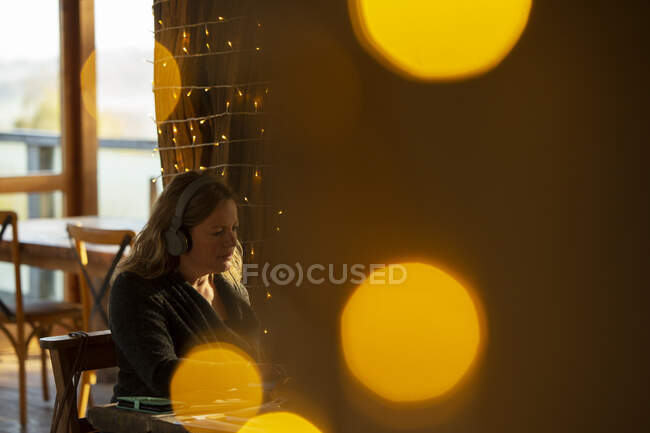 Femme d'affaires avec écouteurs travaillant dans un café — Photo de stock