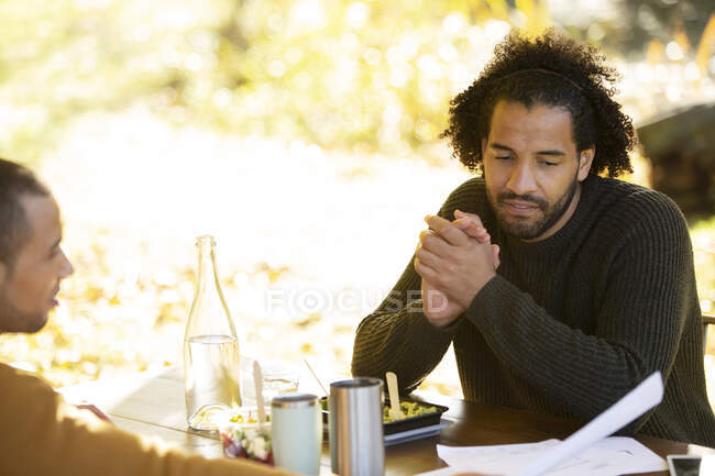 Businessmen discussing paperwork over lunch in park — Stock Photo