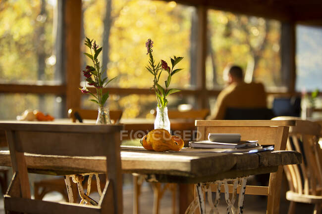Wildblumenstrauß und Herbstkürbisse auf rustikalem Cafétisch — Stockfoto