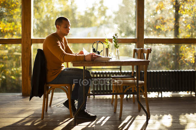 Empresário com papelada trabalhando no ensolarado café de outono — Fotografia de Stock