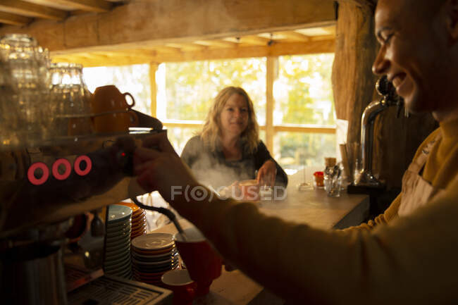 Barista preparando café para el cliente en la máquina de café expreso en la cafetería - foto de stock