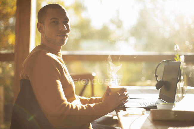 Portrait confident businessman with hot coffee working in cafe — Stock Photo