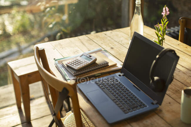Ноутбук, навушники, калькулятор і зошити на столі кафе. — стокове фото