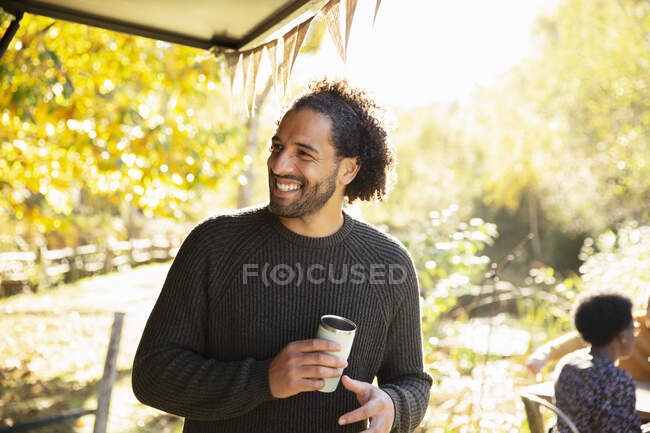 Glücklicher Mann mit Kaffee im sonnigen Herbstpark — Stockfoto
