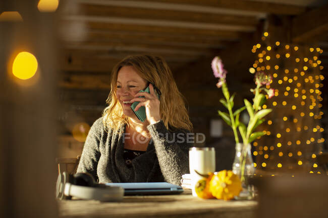 Happy businesswoman talking on smart phone working in cafe — Stock Photo