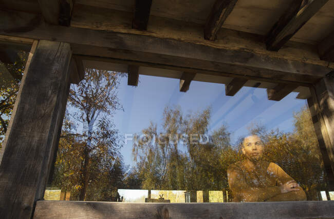 Удумливий чоловік дивиться на осінні дерева з вікна кафе — стокове фото
