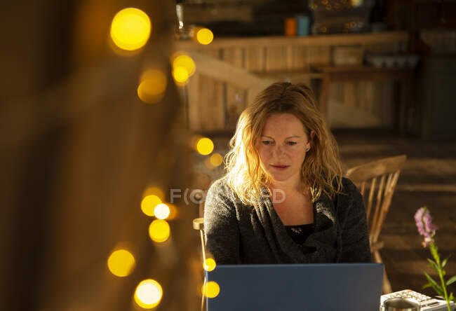 Femme d'affaires concentrée travaillant à un ordinateur portable dans un café — Photo de stock