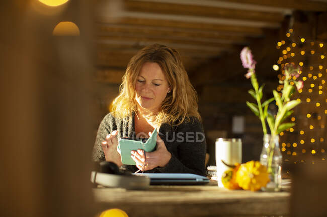 Бизнесмен, использующая смартфон за столом кафе — стоковое фото