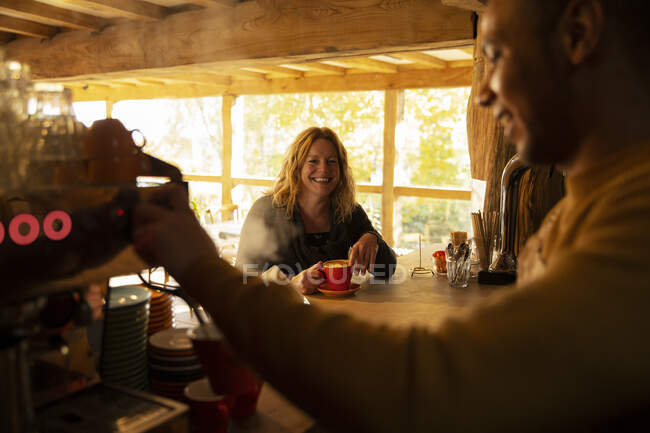 Customer watching barista prepare coffee at espresso machine in cafe — Stock Photo