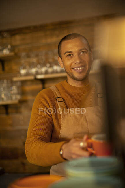 Портрет улыбающийся уверенный мужчина-бариста готовит кофе в кафе — стоковое фото